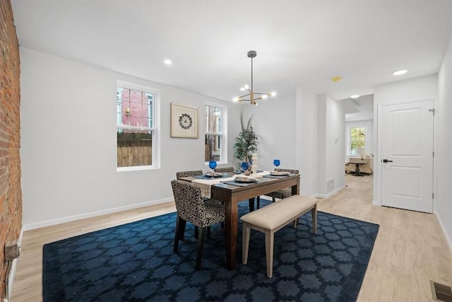 dining area featuring an inviting chandelier and light hardwood / wood-style flooring