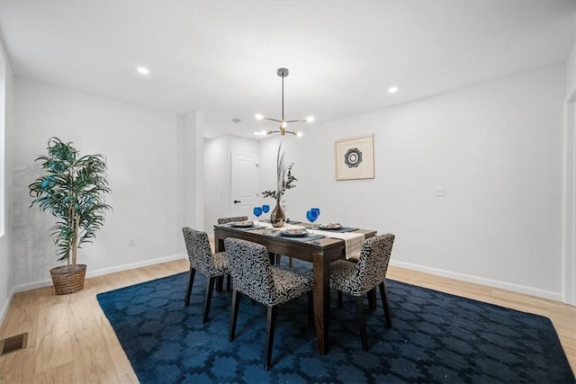 dining space featuring an inviting chandelier and hardwood / wood-style flooring