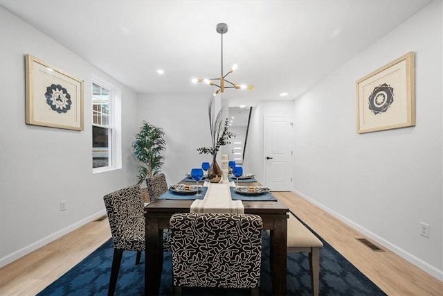 dining room with hardwood / wood-style floors and a notable chandelier