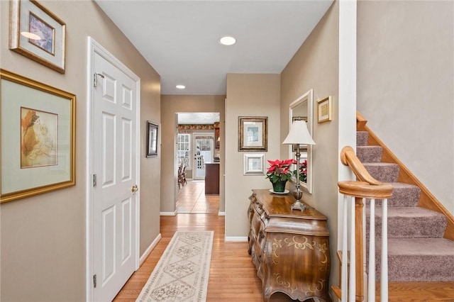 corridor with light hardwood / wood-style flooring and french doors