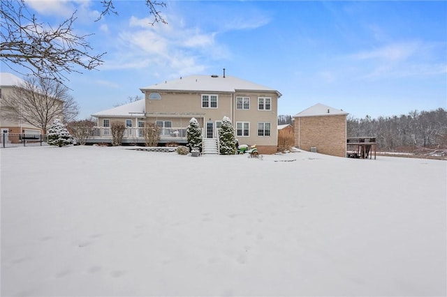 snow covered property with a wooden deck