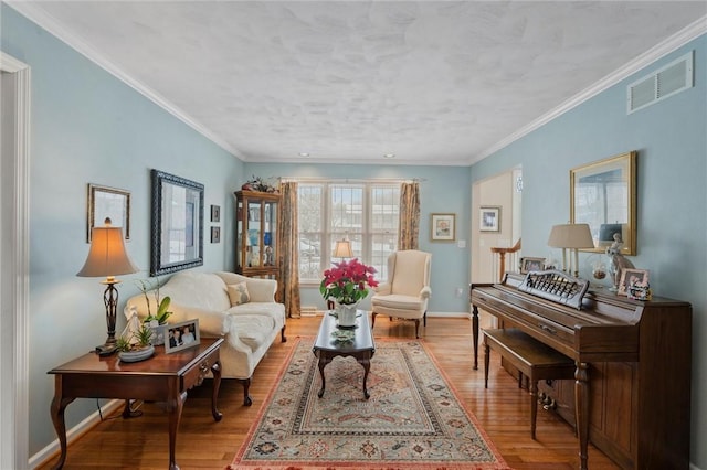 sitting room with crown molding and light hardwood / wood-style floors