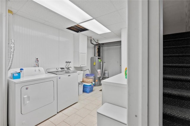 clothes washing area featuring light tile patterned floors, independent washer and dryer, and gas water heater