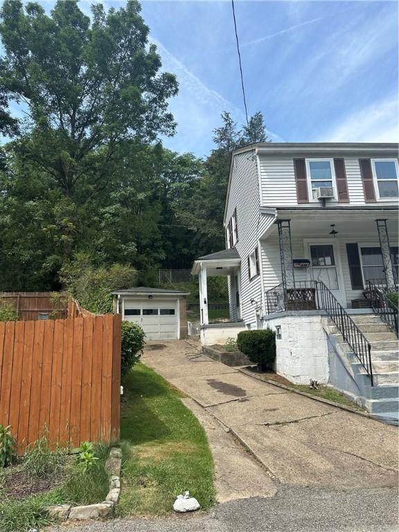 view of front of house featuring covered porch, a garage, and an outdoor structure