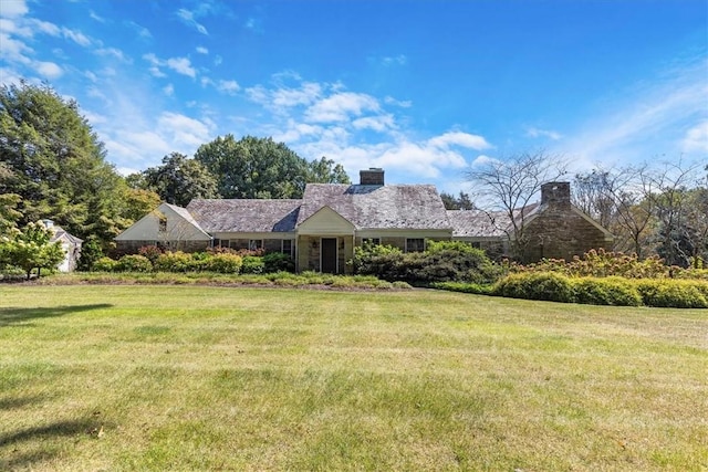 view of front of property featuring a chimney and a front yard