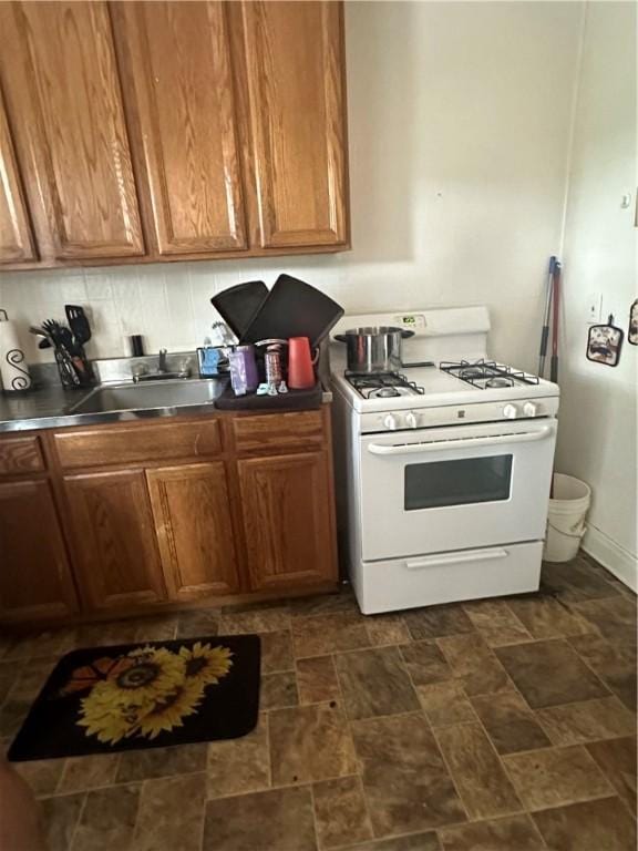 kitchen featuring white range with gas cooktop and sink