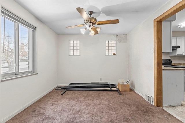 carpeted empty room featuring ceiling fan and a healthy amount of sunlight