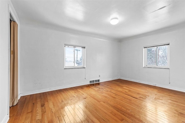 unfurnished room with light hardwood / wood-style floors and a wealth of natural light