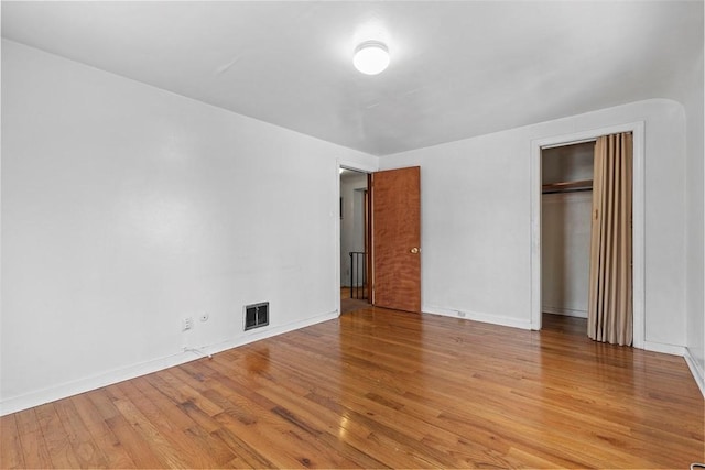 unfurnished bedroom featuring a closet and light hardwood / wood-style flooring