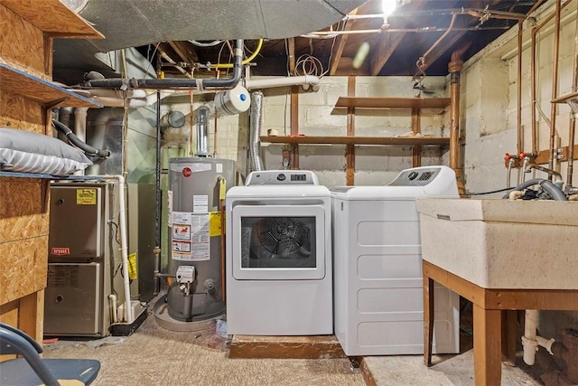 laundry room featuring sink, heating unit, gas water heater, and independent washer and dryer