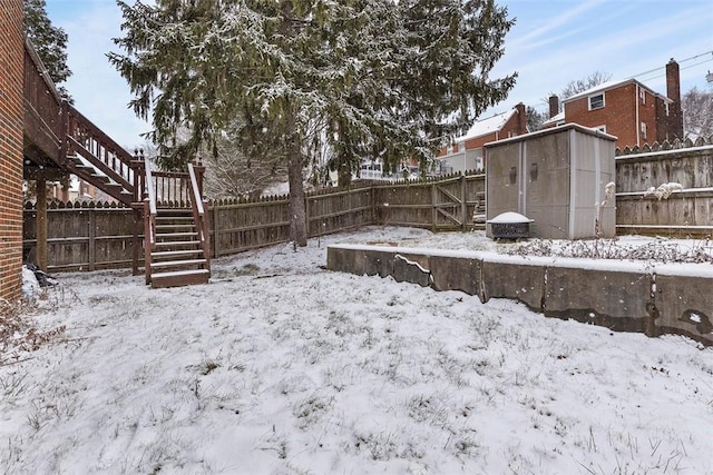 yard layered in snow with a shed