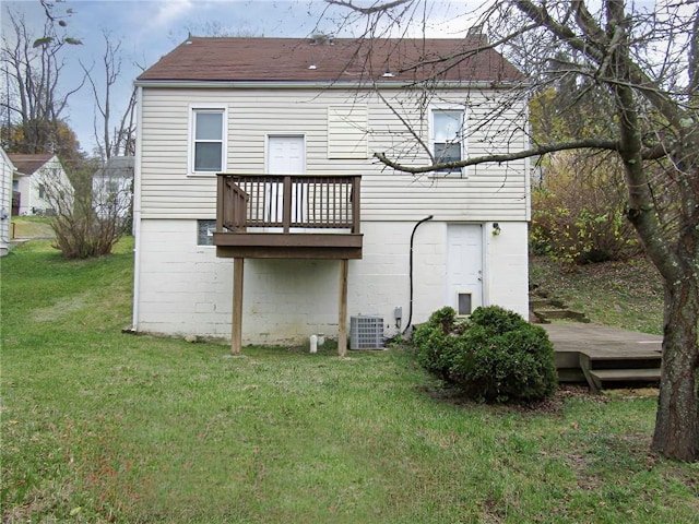 rear view of property with a wooden deck and a yard