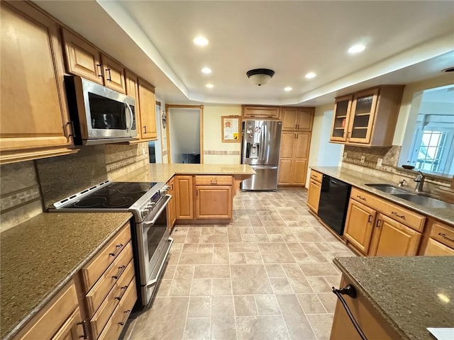 kitchen featuring sink, appliances with stainless steel finishes, kitchen peninsula, and tasteful backsplash