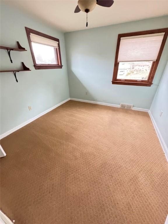 empty room with ceiling fan and carpet flooring