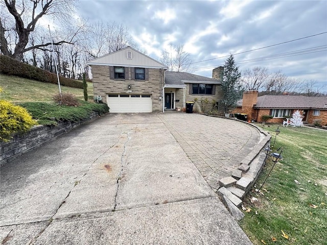 split level home featuring a garage and a front lawn