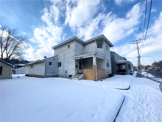 view of snow covered rear of property