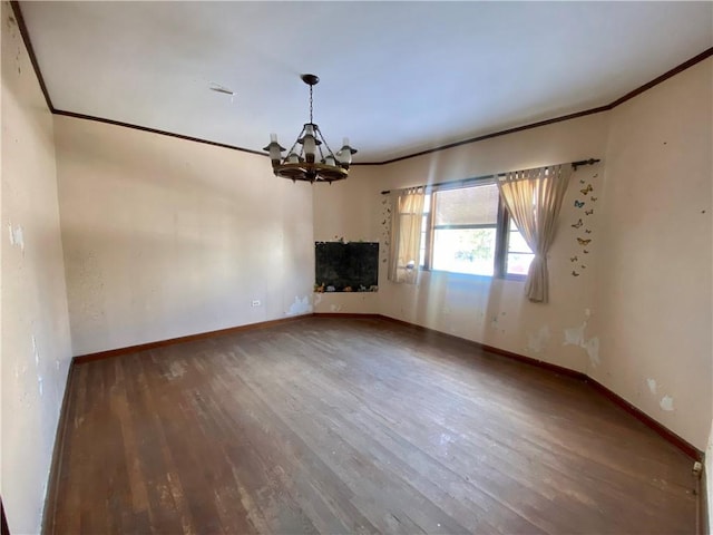 spare room with an inviting chandelier, ornamental molding, and wood-type flooring