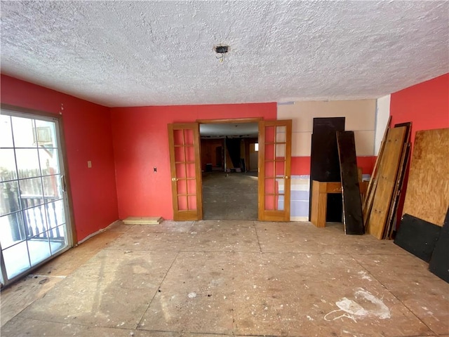 unfurnished room featuring a textured ceiling and french doors