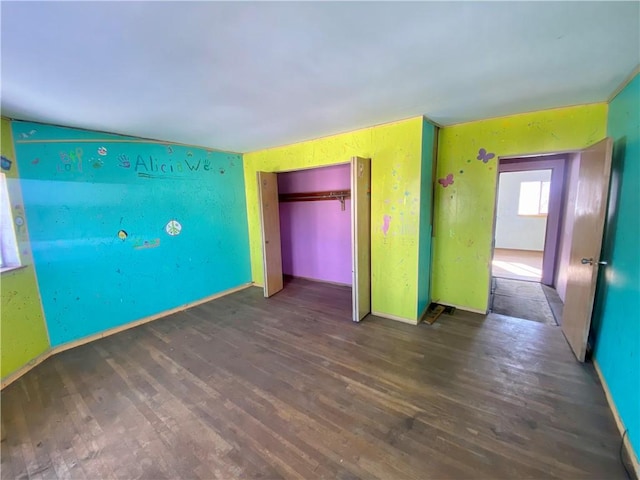 unfurnished bedroom featuring a closet and dark hardwood / wood-style floors