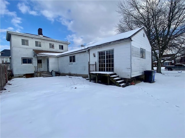 view of snow covered rear of property