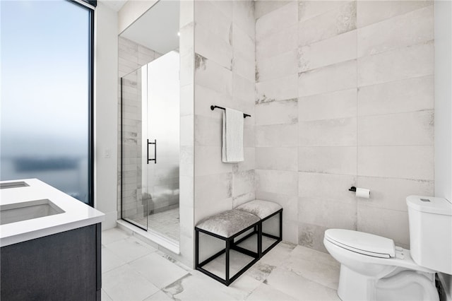 bathroom featuring walk in shower, vanity, toilet, and a wall of windows