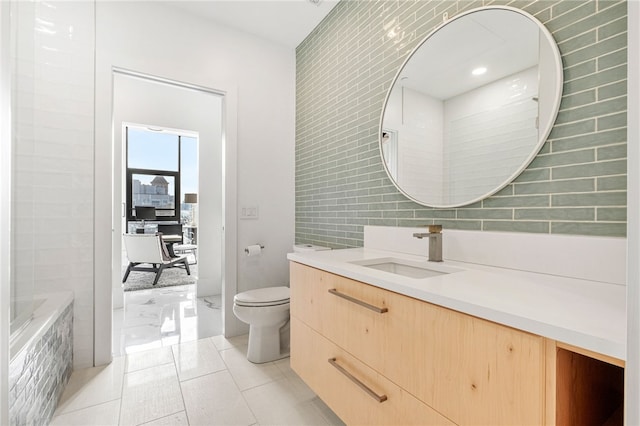 bathroom featuring tile patterned flooring, vanity, tile walls, toilet, and a washtub