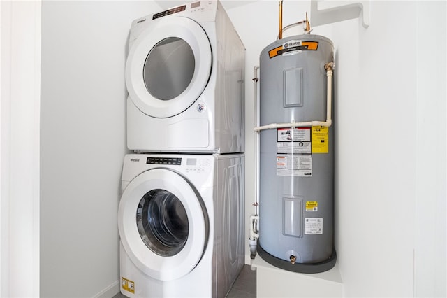 laundry room with electric water heater and stacked washing maching and dryer