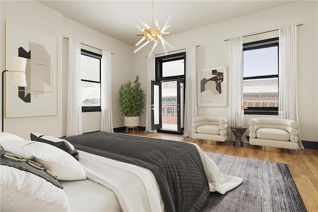 bedroom with access to exterior, multiple windows, and light hardwood / wood-style floors