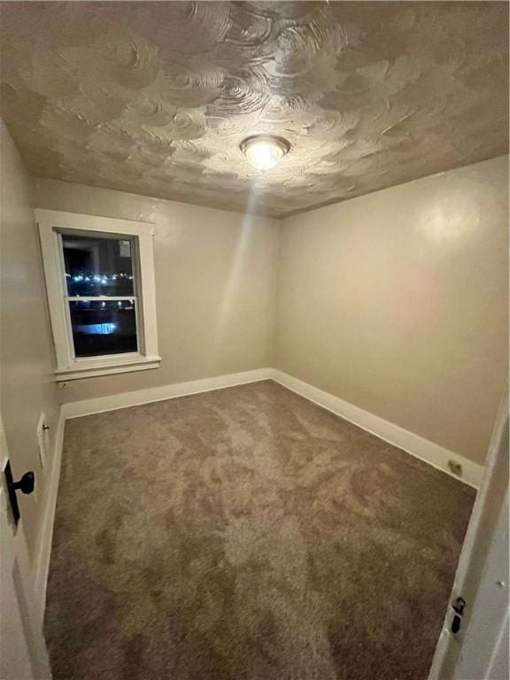 carpeted empty room featuring a textured ceiling