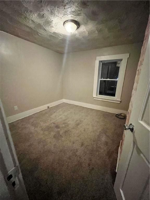 unfurnished room featuring carpet and baseboards