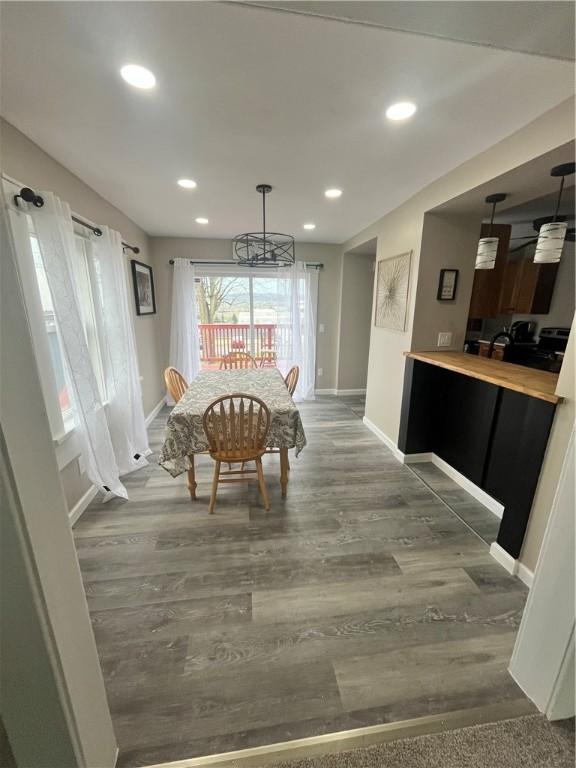dining area with wood finished floors, baseboards, recessed lighting, and a chandelier