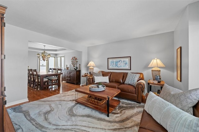 living room featuring a notable chandelier and light wood-type flooring