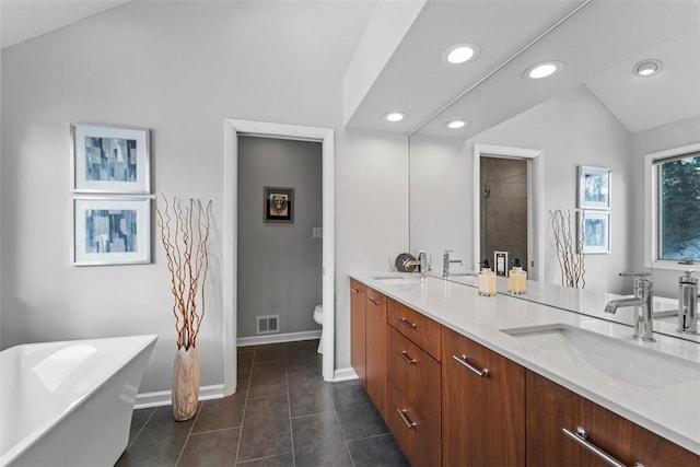 bathroom with toilet, a bathing tub, tile patterned flooring, lofted ceiling, and vanity