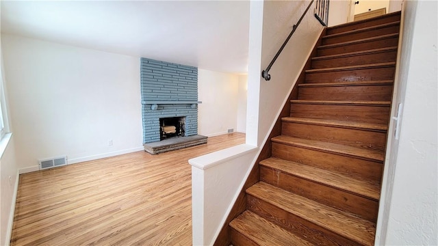 stairway featuring a fireplace and hardwood / wood-style flooring