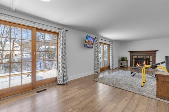 living room featuring a tile fireplace and light hardwood / wood-style flooring