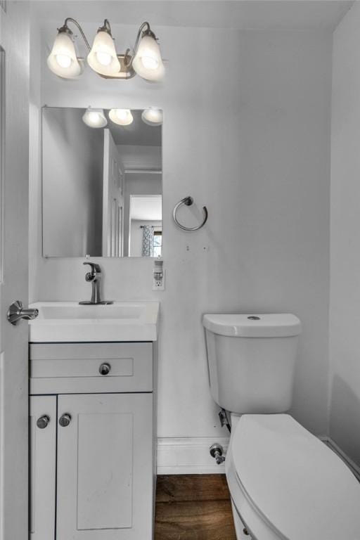 bathroom featuring toilet, hardwood / wood-style floors, and vanity