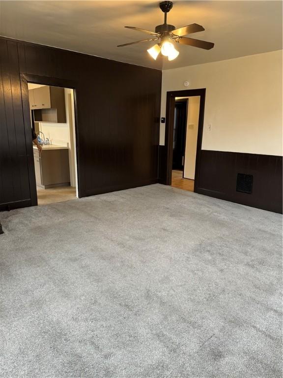 unfurnished room with ceiling fan and light carpet