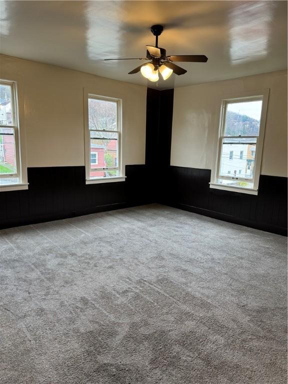 carpeted empty room featuring ceiling fan