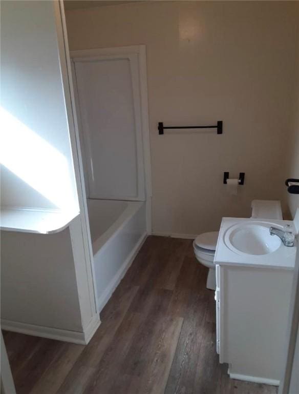 bathroom with toilet, hardwood / wood-style floors, and vanity