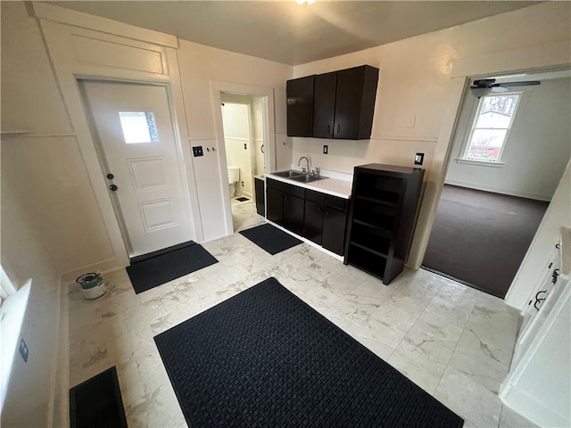 kitchen with ceiling fan, sink, white cabinets, and dark brown cabinets