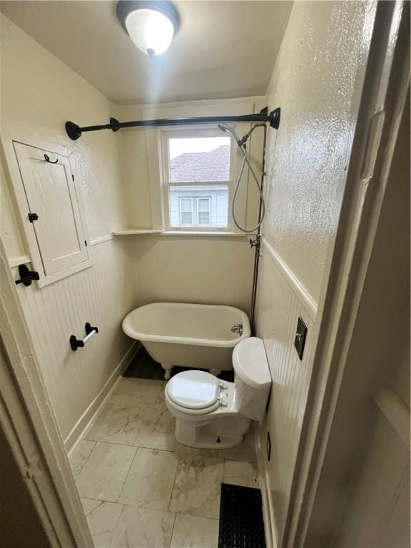 bathroom featuring toilet and a washtub