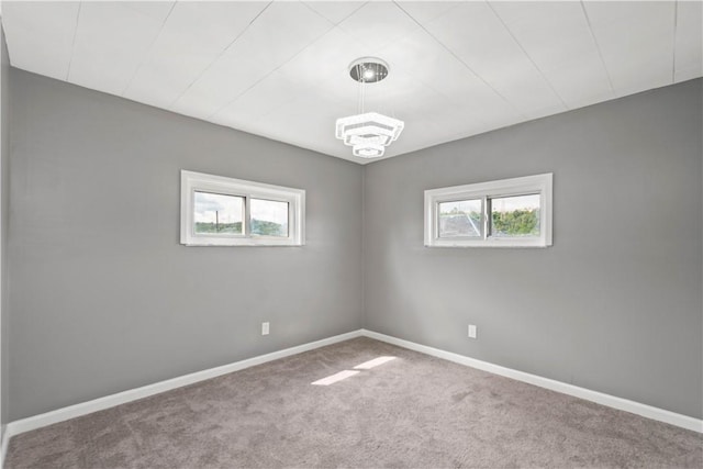 empty room with a healthy amount of sunlight, carpet, and baseboards