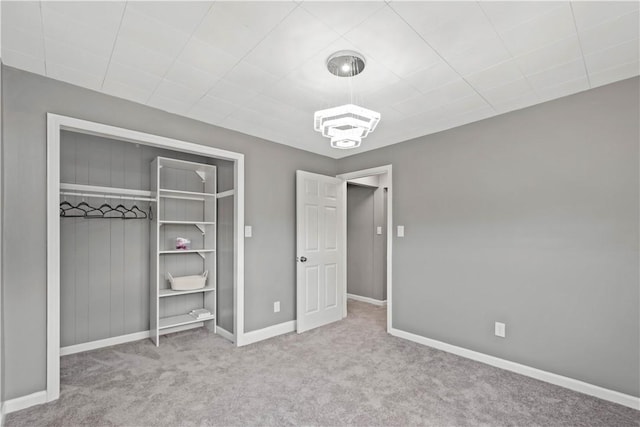 unfurnished bedroom featuring a closet, baseboards, and carpet flooring