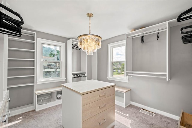 walk in closet featuring visible vents, a notable chandelier, and light colored carpet