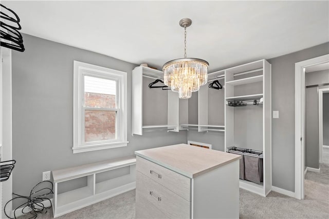 walk in closet featuring light carpet and a notable chandelier