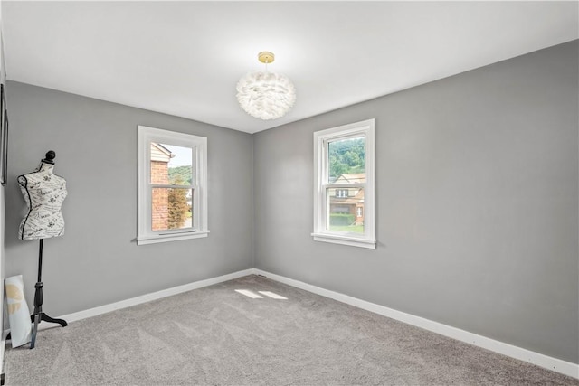 empty room with carpet, plenty of natural light, and baseboards