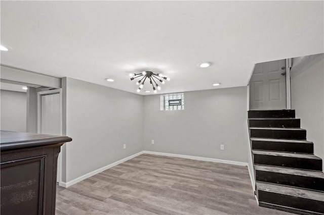 below grade area featuring stairs, light wood finished floors, and baseboards