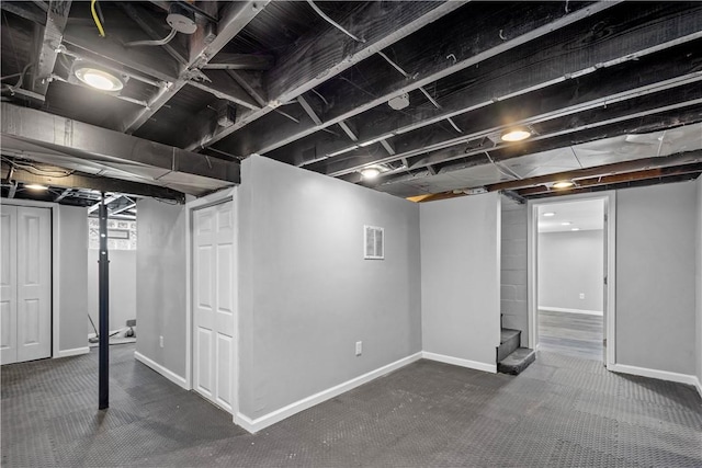 below grade area with carpet, baseboards, and visible vents