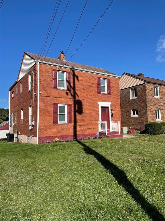 back of property featuring a lawn and central AC