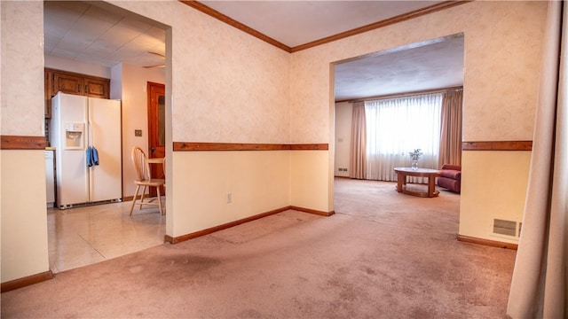 carpeted empty room featuring crown molding